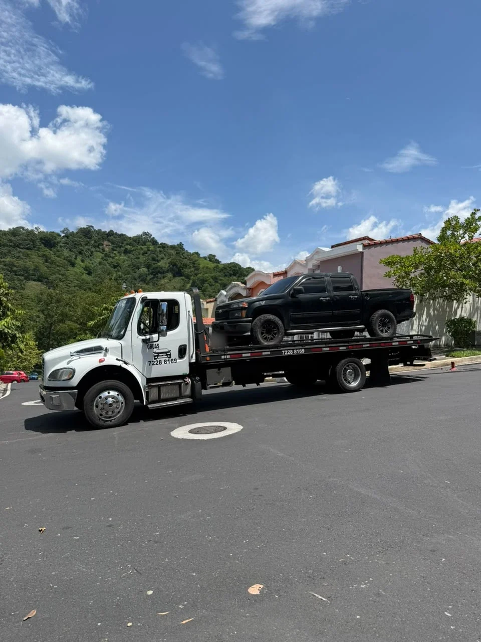 Grúa trasladando una pick-up negra