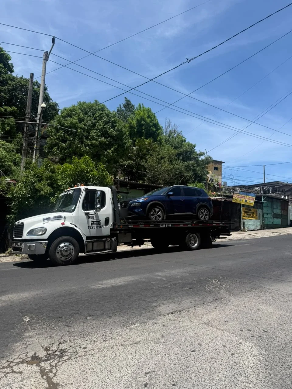 Grúa de plataforma de Grúas Evolution trasladando una camioneta azul